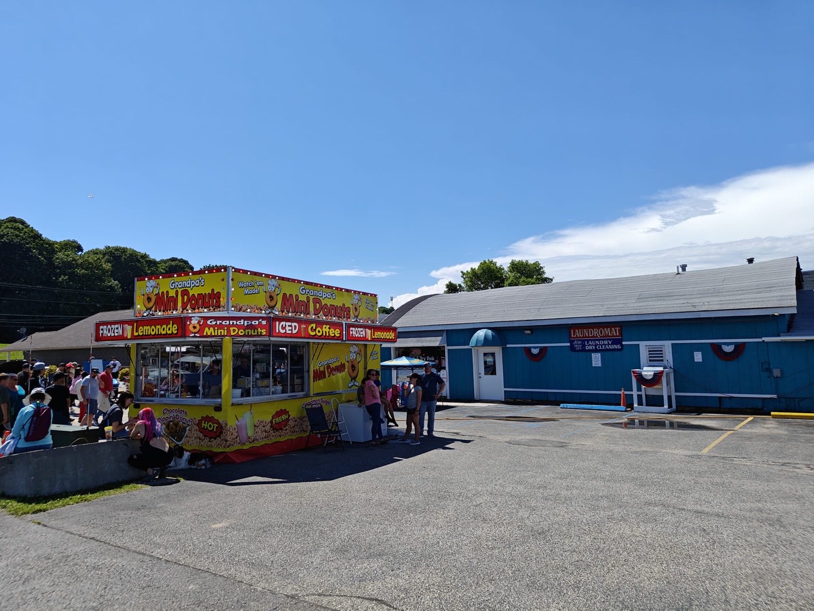 Bayside Coin Laundry's blue building and parking lot in St. Ignace, with the laundromat and drop-off dry cleaning sign