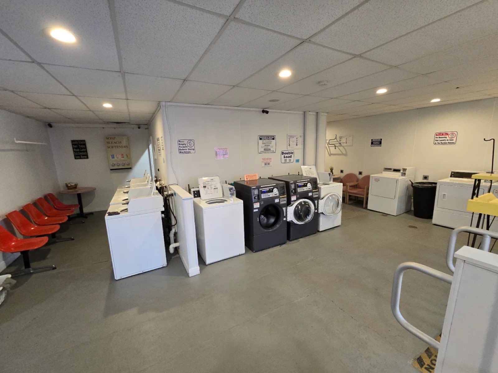 Top-load washers, double-load front-loaders, and dryers inside Bayside Coin Laundry